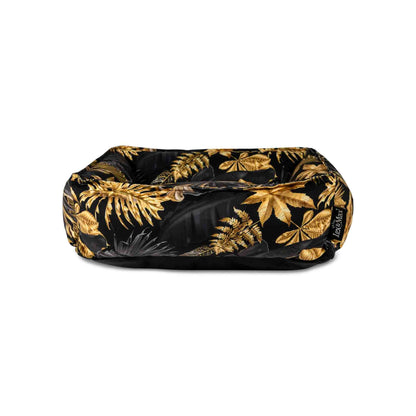 Voorkant hondenmand met tropische bladeren print in zwart en goudtinten.