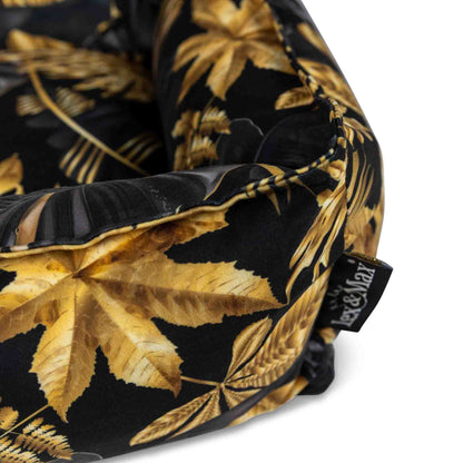 Details hondenmand met tropische bladeren print in zwart en goudtinten.